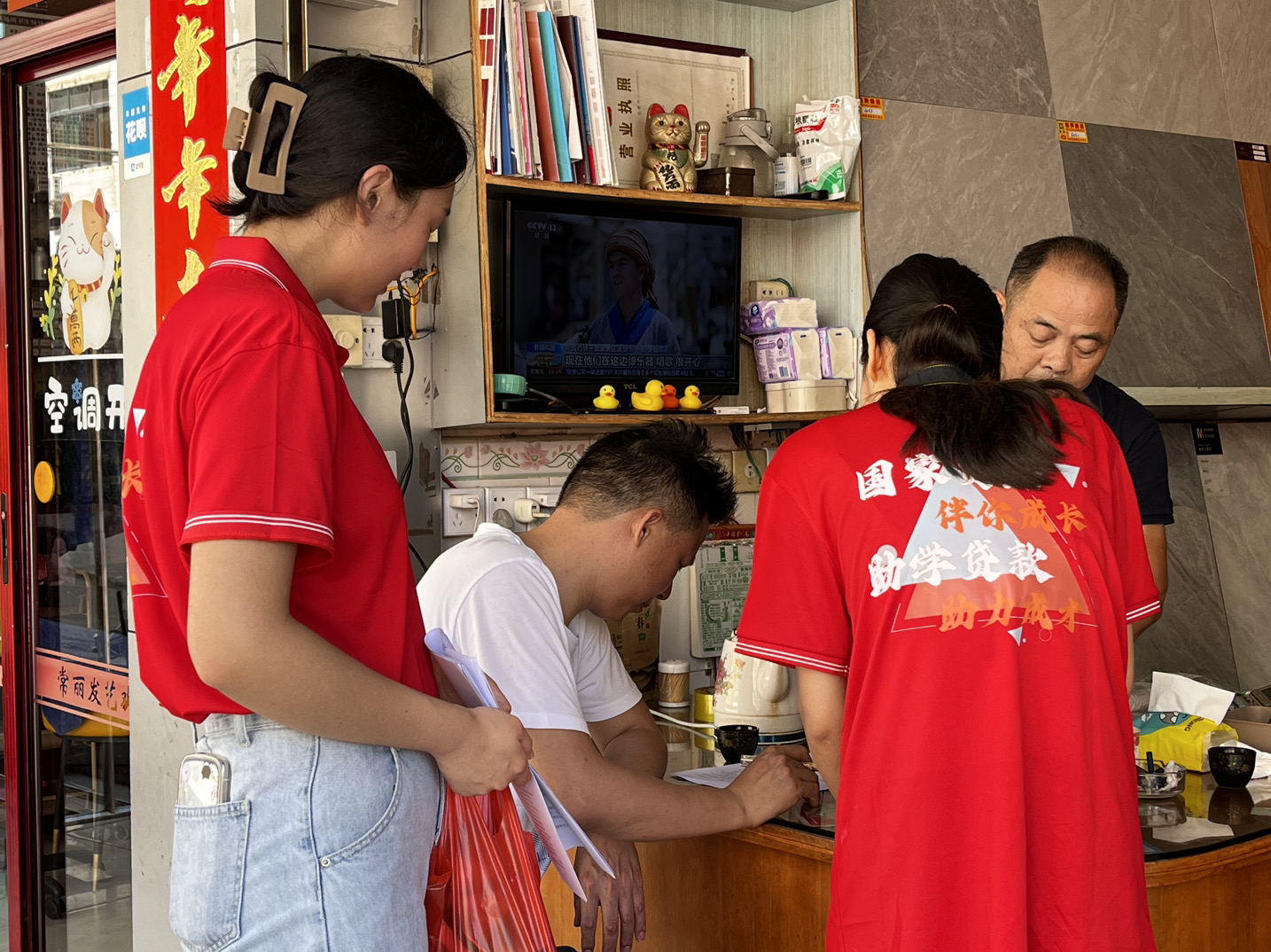 圖為融媒體資助宣傳實踐隊隊員走訪宣傳資助政策現場。(林琳 供圖)