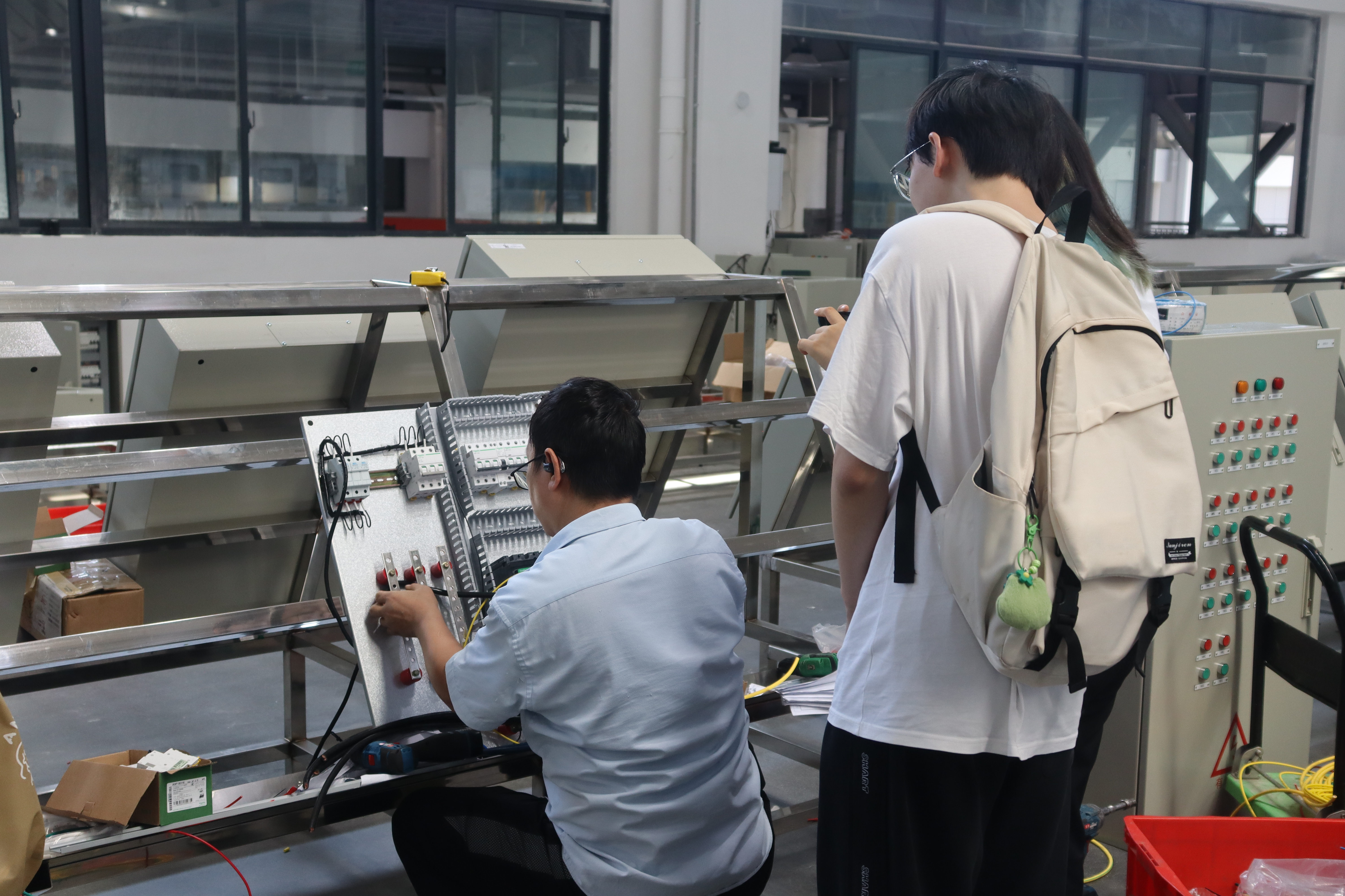 圖為調研團成員參觀興屹集團工廠生產流水線 馮子翔攝